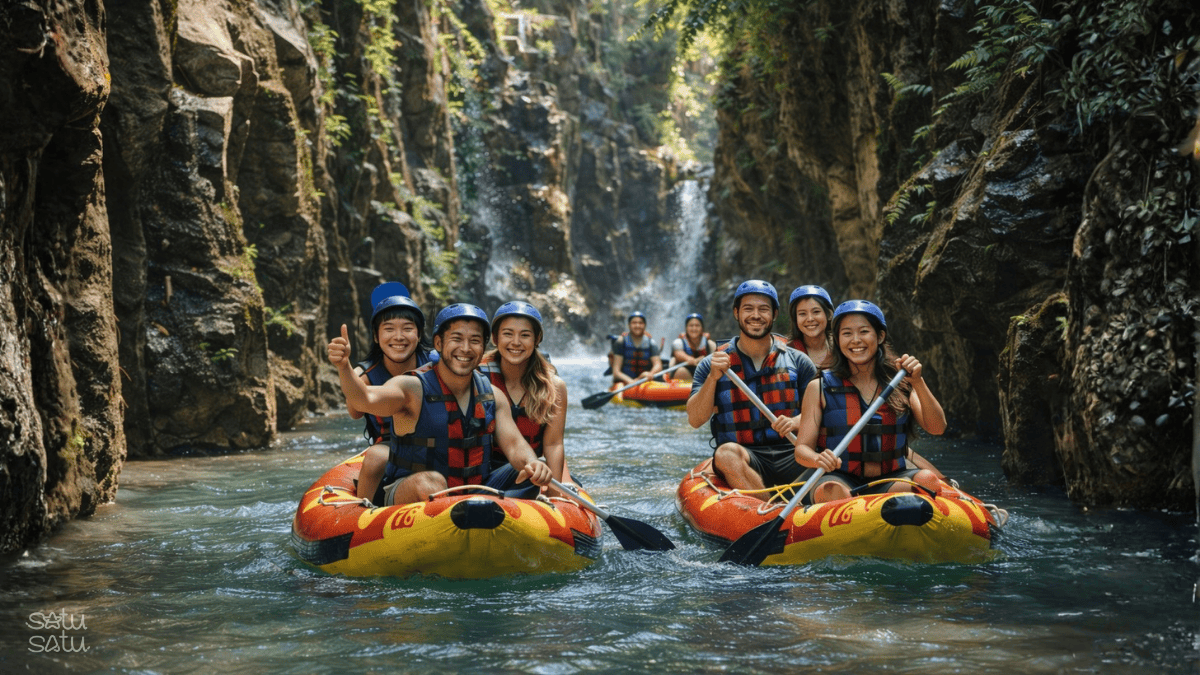Group of travelers enjoying white water rafting on Melangit River in Bali, surrounded by lush canyon cliffs and tropical rainforest.