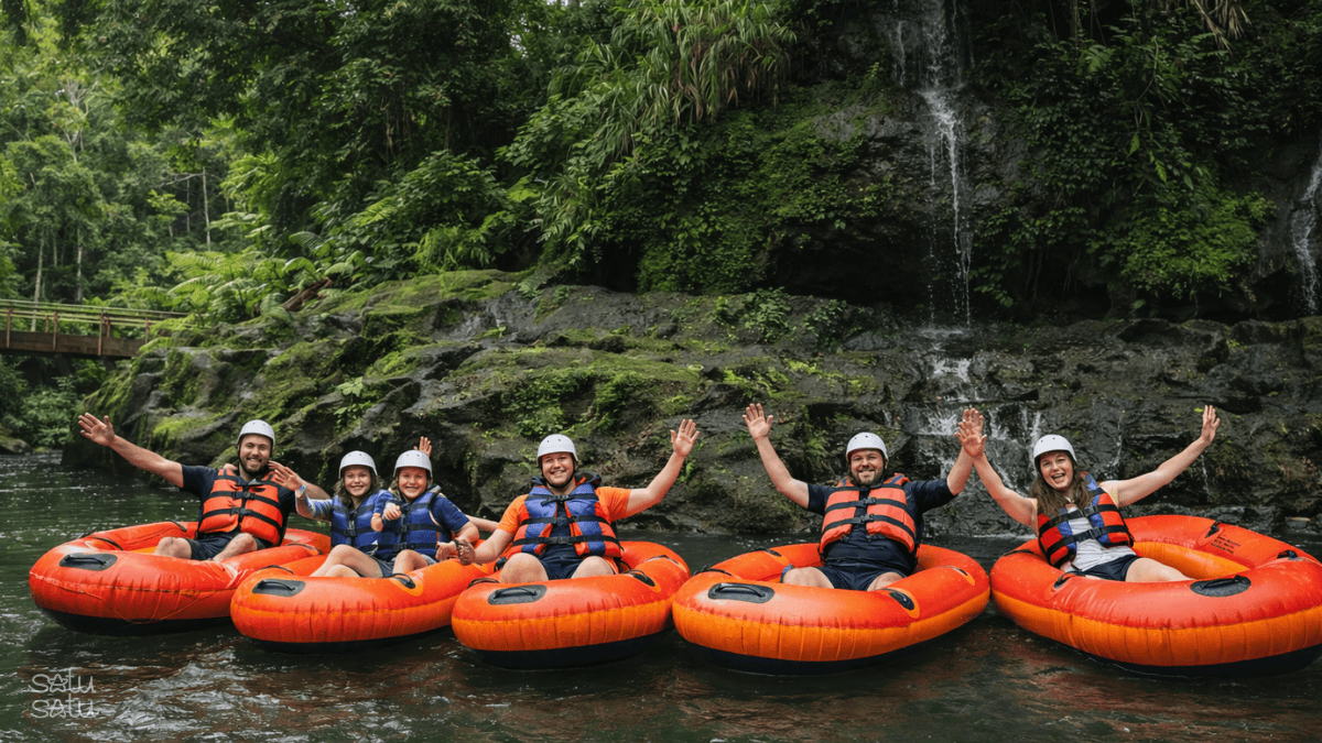 Group of travelers enjoying river tubing on Pakerisan River in Bali, floating through lush tropical jungle with cascading waterfalls.