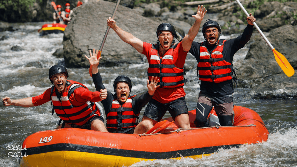 Group of travelers white water rafting on Ayung River in Bali, navigating rapids with excitement.
