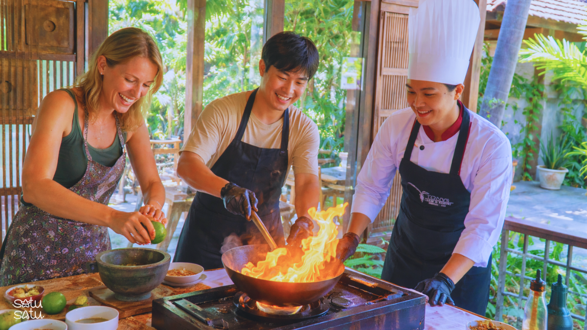 Travelers learning traditional Balinese cooking with a local chef during a hands-on cooking class in Bali
