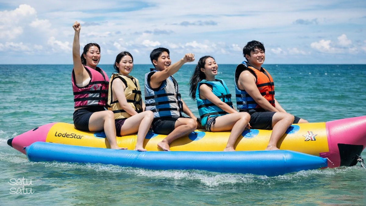 Korean travelers enjoying a banana boat ride during a water sports activity in Bali, Indonesia