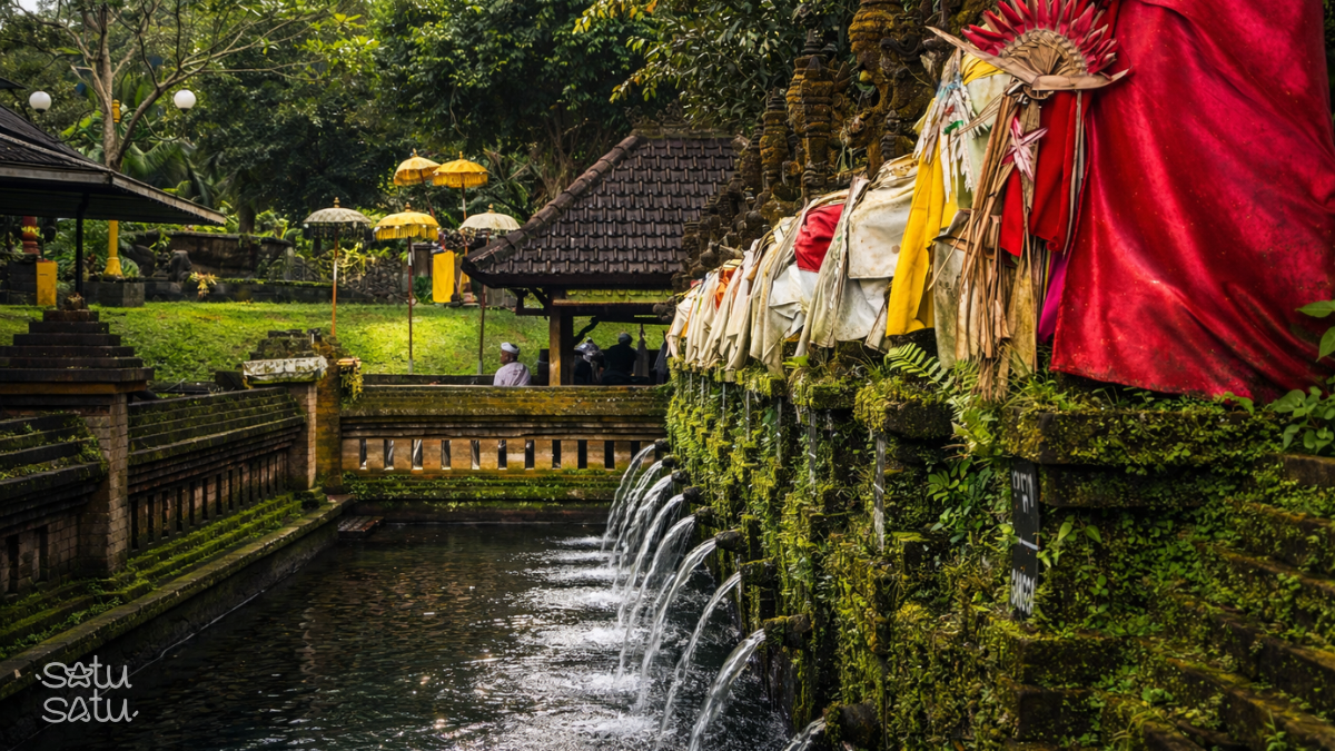 Pancoran Solas in Bali, a sacred melukat purification site with multiple holy water spouts flowing into a traditional stone pool.