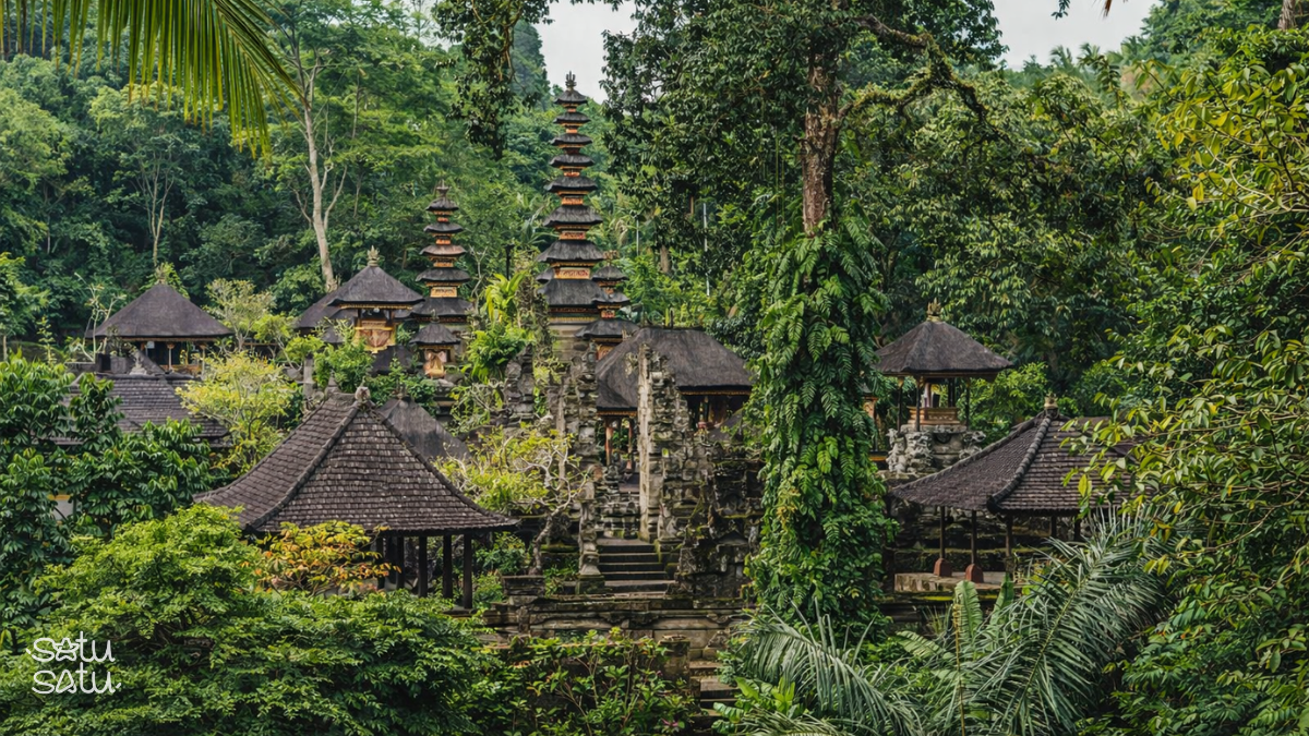 Puri Gunung Lebah temple complex in Ubud Bali surrounded by lush tropical forest seen from a distance