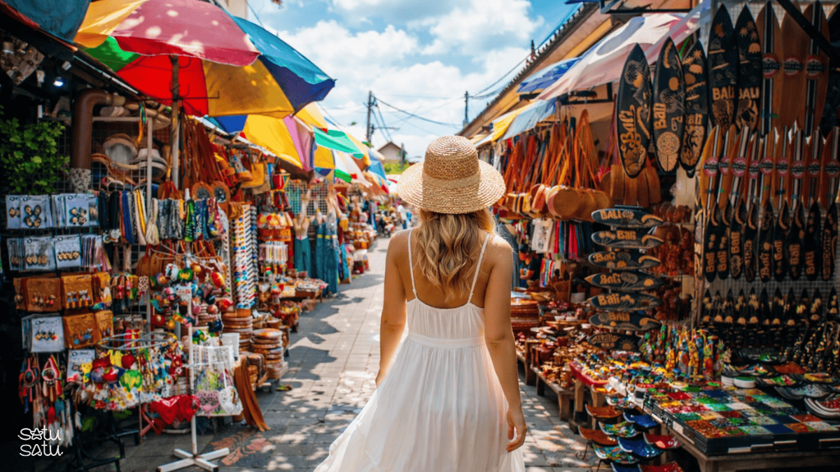 Traveler walking through Ubud Art Market in Bali surrounded by colorful handicrafts, souvenirs, and traditional artisan stalls.