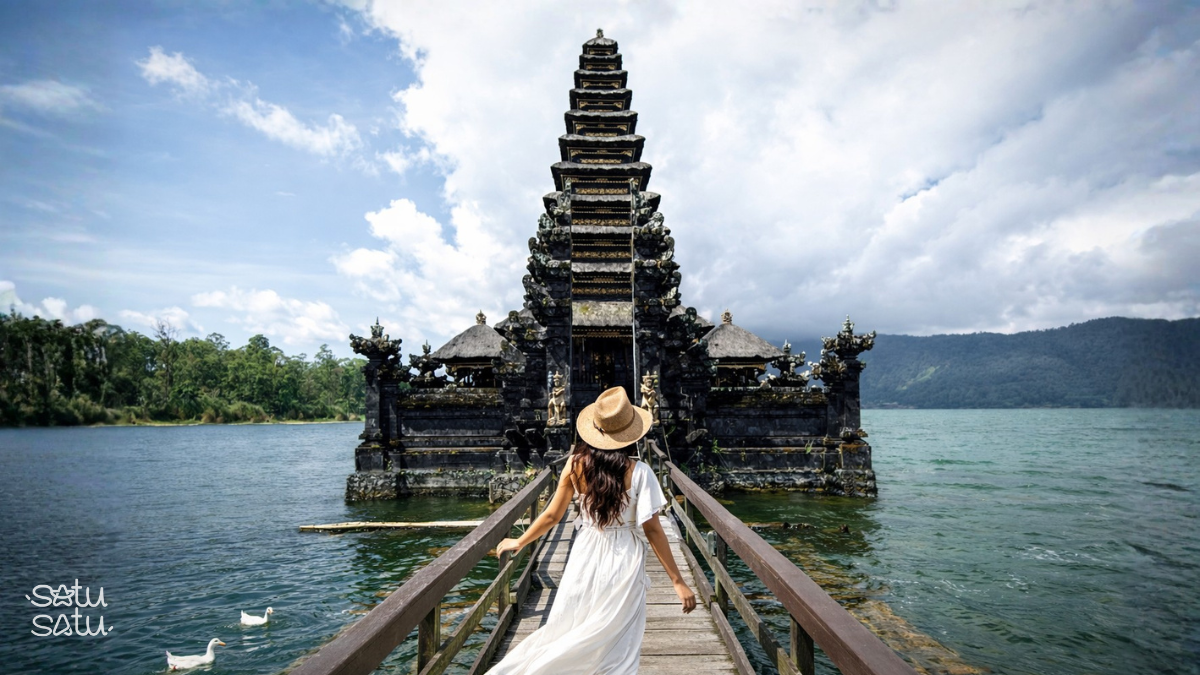 Female traveler walking toward Ulun Danu Batur Temple by the lake in Bali.