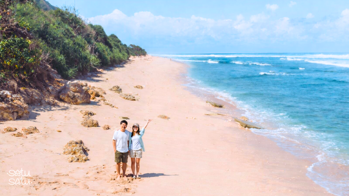 Travelers relaxing on the sandy coastline of Nyang Nyang Beach in Bali with ocean waves and tropical scenery